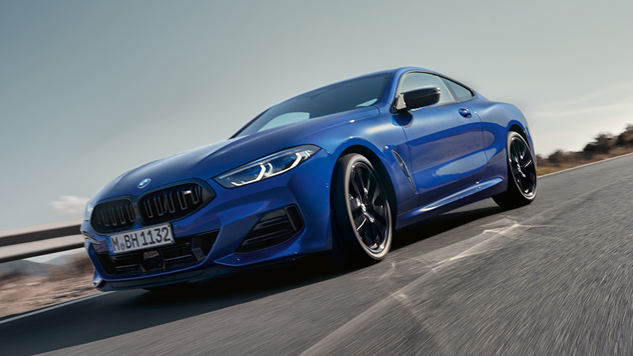 BMW 8 серии Coupé G15 LCI (рестайлинг 2022 года) BMW M850i xDrive M цвета Синий Портимау металлик, вид спереди с поворотом в три четверти BMW 8 серии Coupé G15 LCI (рестайлинг 2022 года) BMW M850i xDrive M цвета Синий Портимау металлик в движении, вид спереди с поворотом в три четверти