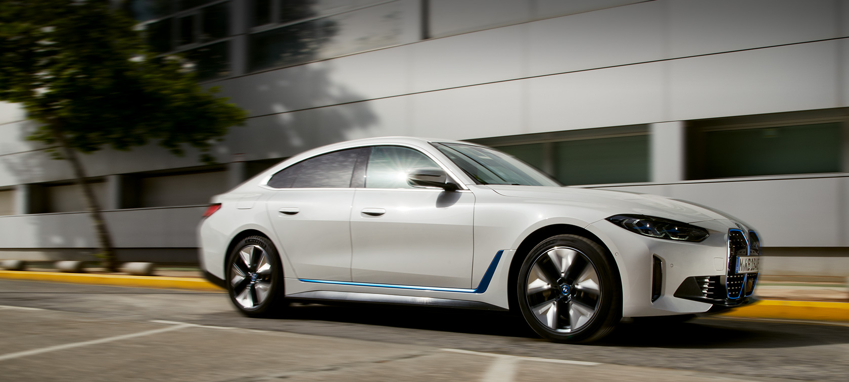 BMW i4 eDrive 40 G26 2021 вид сбоку на три четверти напротив здания