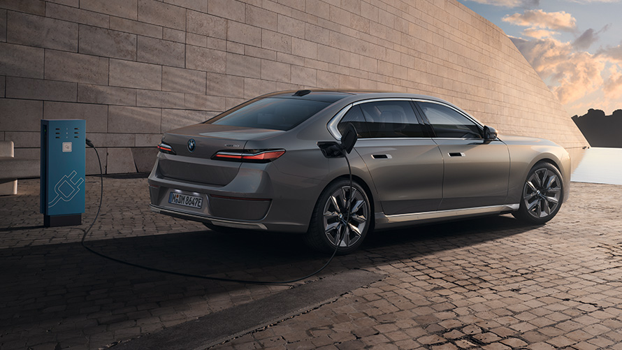 BMW i7, вид три четверти сзади BMW i7 Седан G70 BMW Individual Oxid grey metallic, вид три четверти на зарядной станции