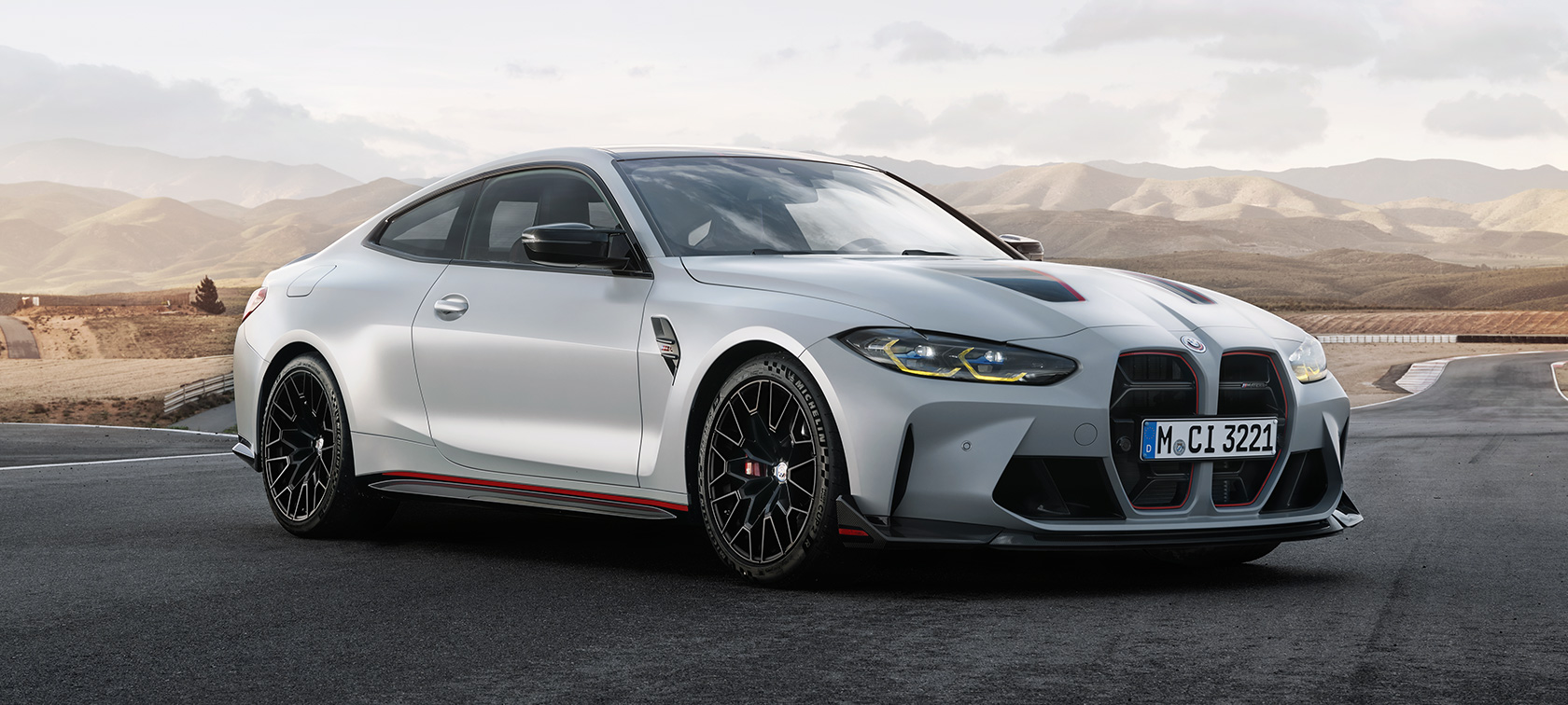 BMW M4 CSL G82, вид спереди в три четверти. BMW M4 CSL G82 в цвете BMW Individual Frozen Brooklyn Grey металлик, вид спереди в три четверти в движении