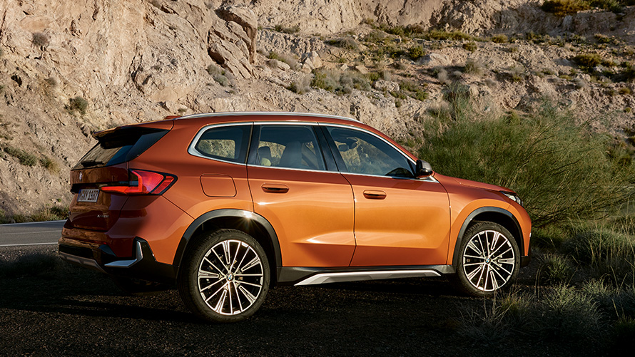 BMW X1 U11 третьего поколения, вид спереди с поворотом в три четверти на дороге BMW X Серии BMW X1 U11третьего поколения, вид спереди с поворотом в три четверти на дороге