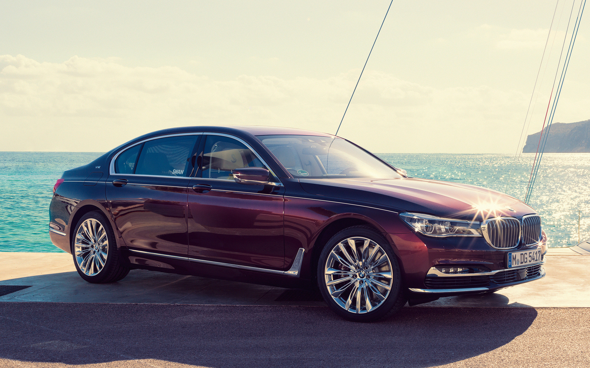 BMW M760Li xDrive Nautor’s Swan – BMW Individual G12 2017 перед яхтой BMW M760Li xDrive Nautor’s Swan – BMW Individual G12 2017, вид сбоку в три четверти на пирсе перед яхтой в заливе