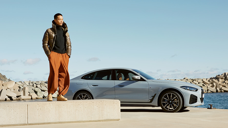 Автомобиль BMW с моделью на фоне летнего пейзажа BMW Service Inclusive Автомобиль BMW с моделью на фоне летнего пейзажа